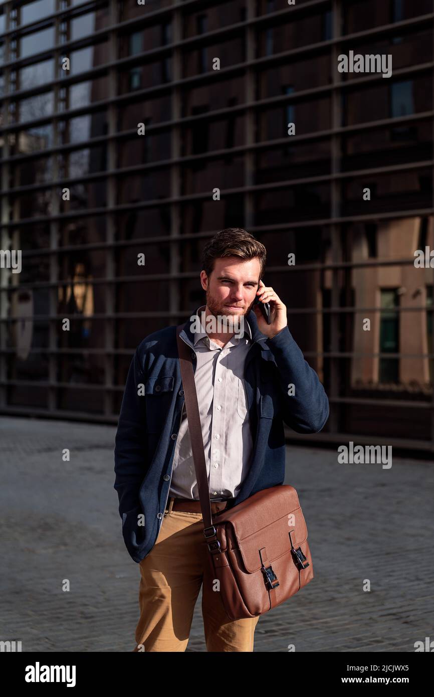young businessman walking talking by phone Stock Photo