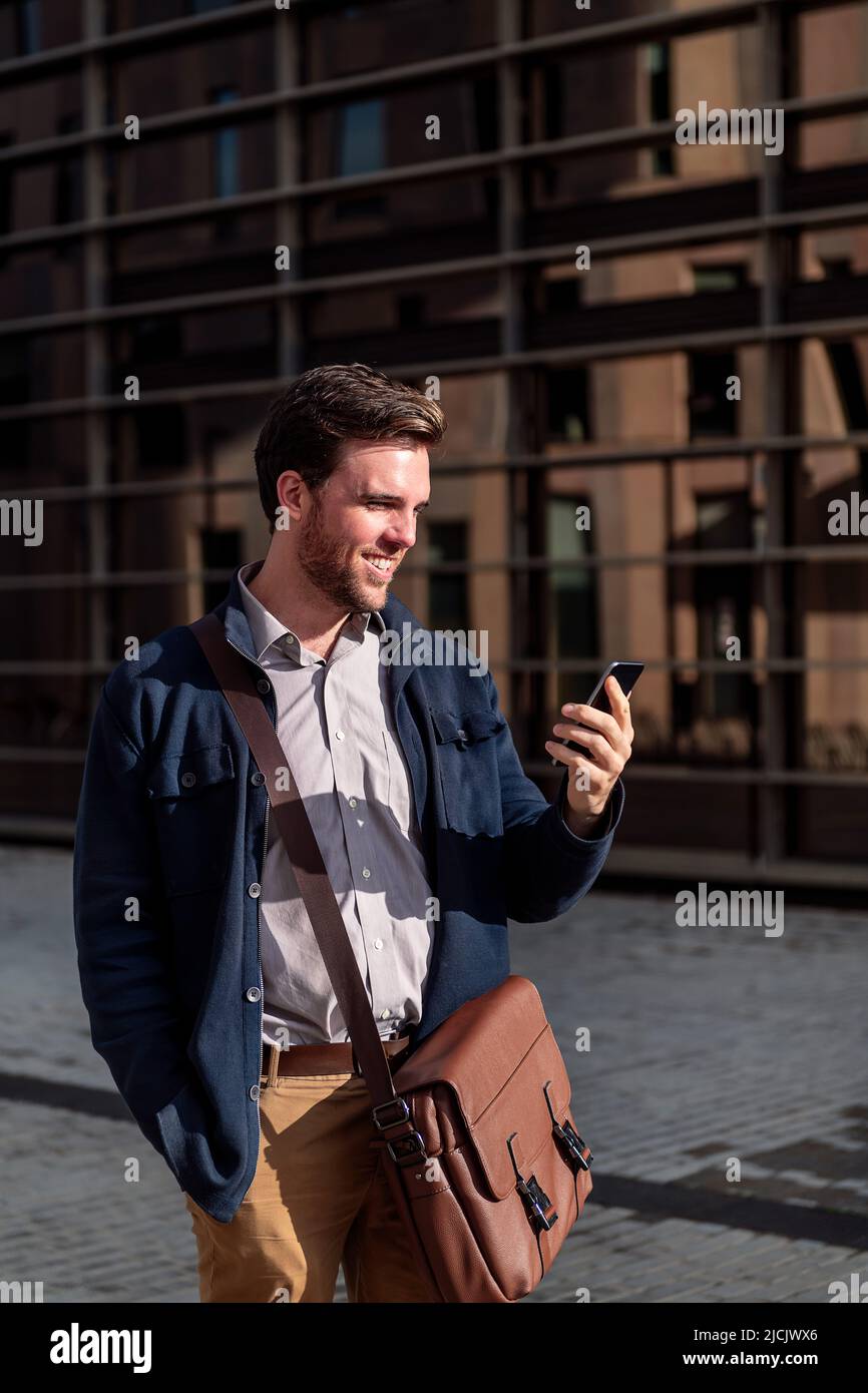 businessman looking phone by an office building Stock Photo