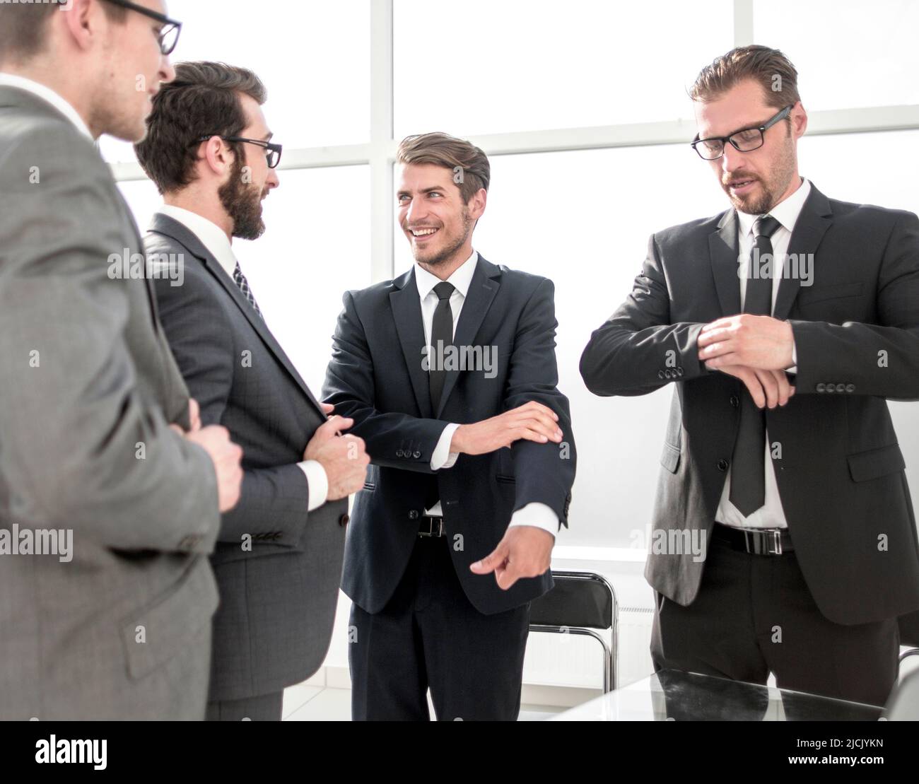young business partners talking standing in the office Stock Photo - Alamy