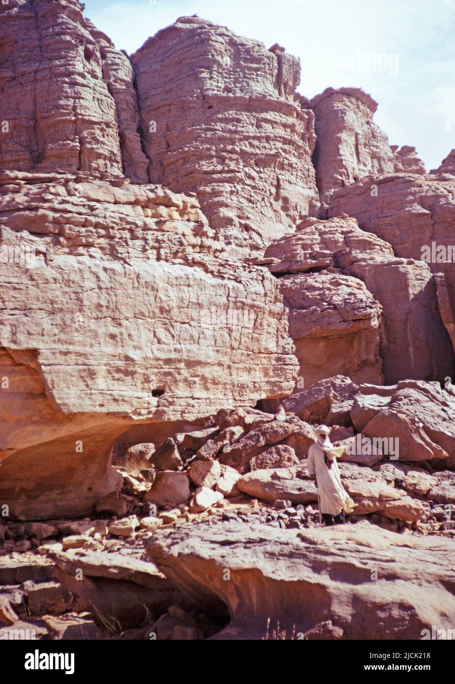 Taureq guide standing by cave dwelling entrance, Tassili plateau, Algeria, North Africa 1973 Tassili N'Ajjer National Park Stock Photo