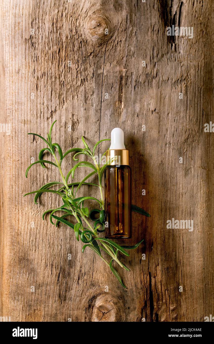 Organic essential rosemary aroma or cosmetic oil from fresh ingredients in glass bottle with pipette. Promo concept for health skin body care antistre Stock Photo