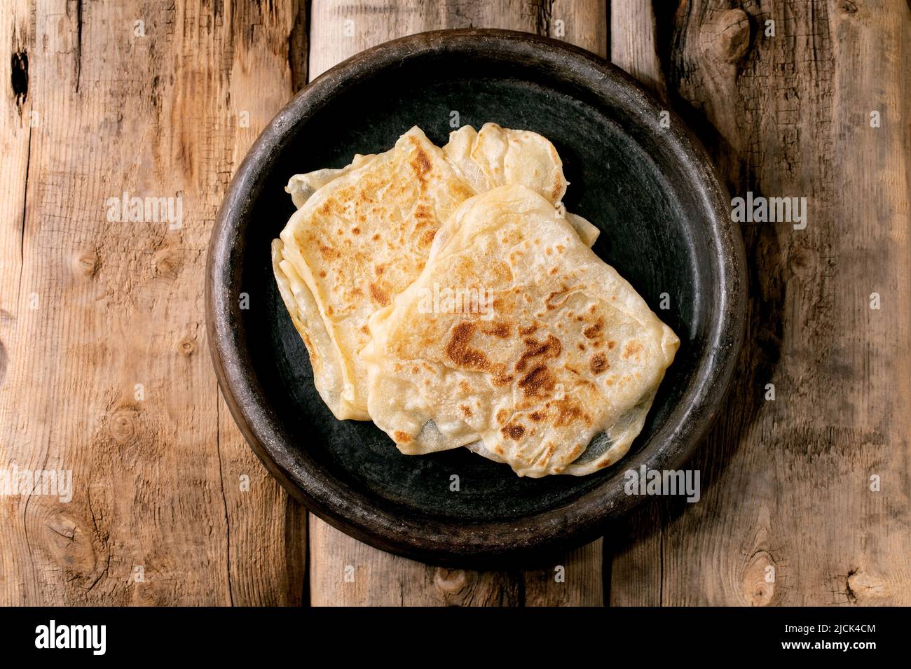 Stack of traditional indian homemade roti flatbread in old ceramic dish ...
