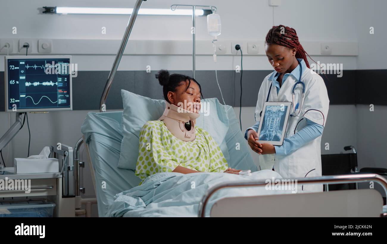 Physician explaining radiography to patient with neck collar in ...