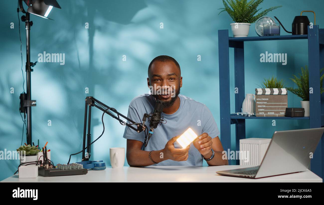 Social media influencer holding white light for review on vlog channel