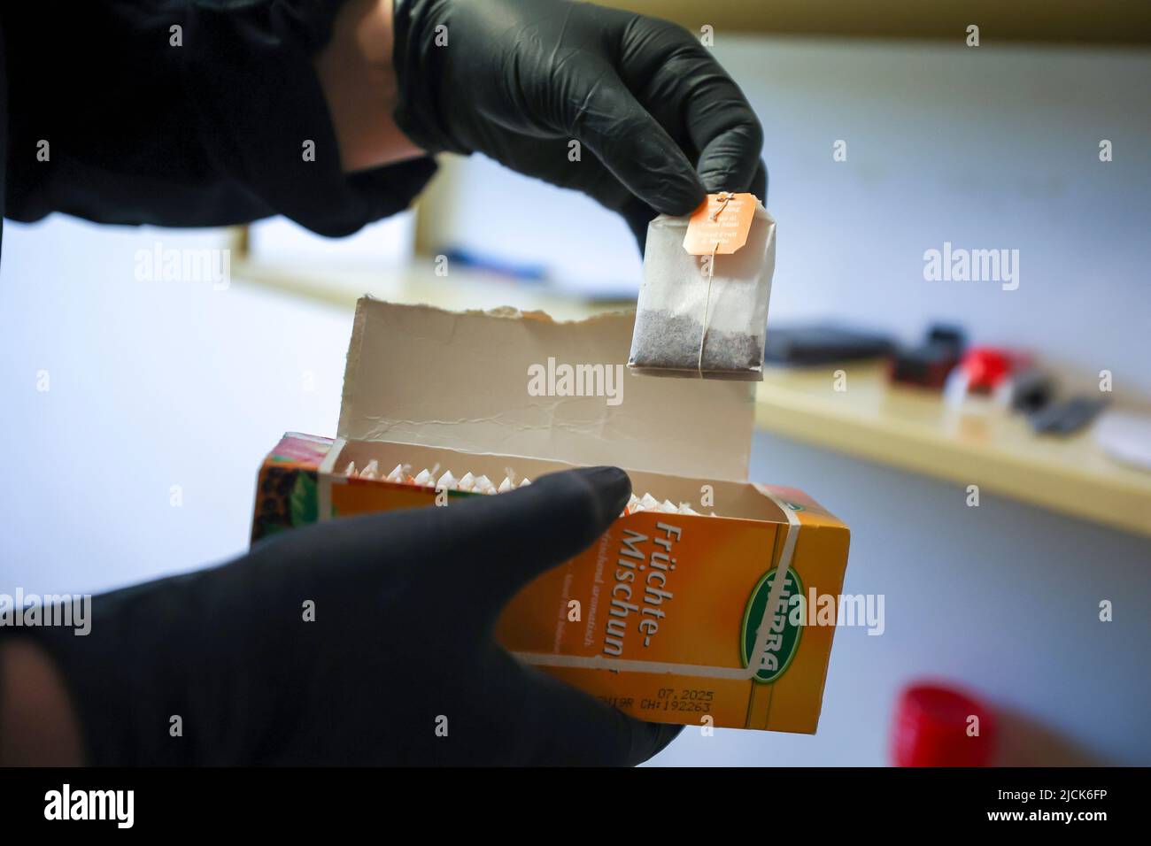 14 June 2022, Saxony-Anhalt, Raßnitz: A female judicial officer of the so-called special security and auditing service (BSRD) searches through tea bags as a popular hiding place in a detention room Auditing operation at the Raßnitz Juvenile Institution (JA). About 12 of these inspections are carried out in all detention centers each year. The aim is to find prohibited items such as weapons or storage media, as well as alcohol and drugs. Photo: Jan Woitas/dpa Stock Photo