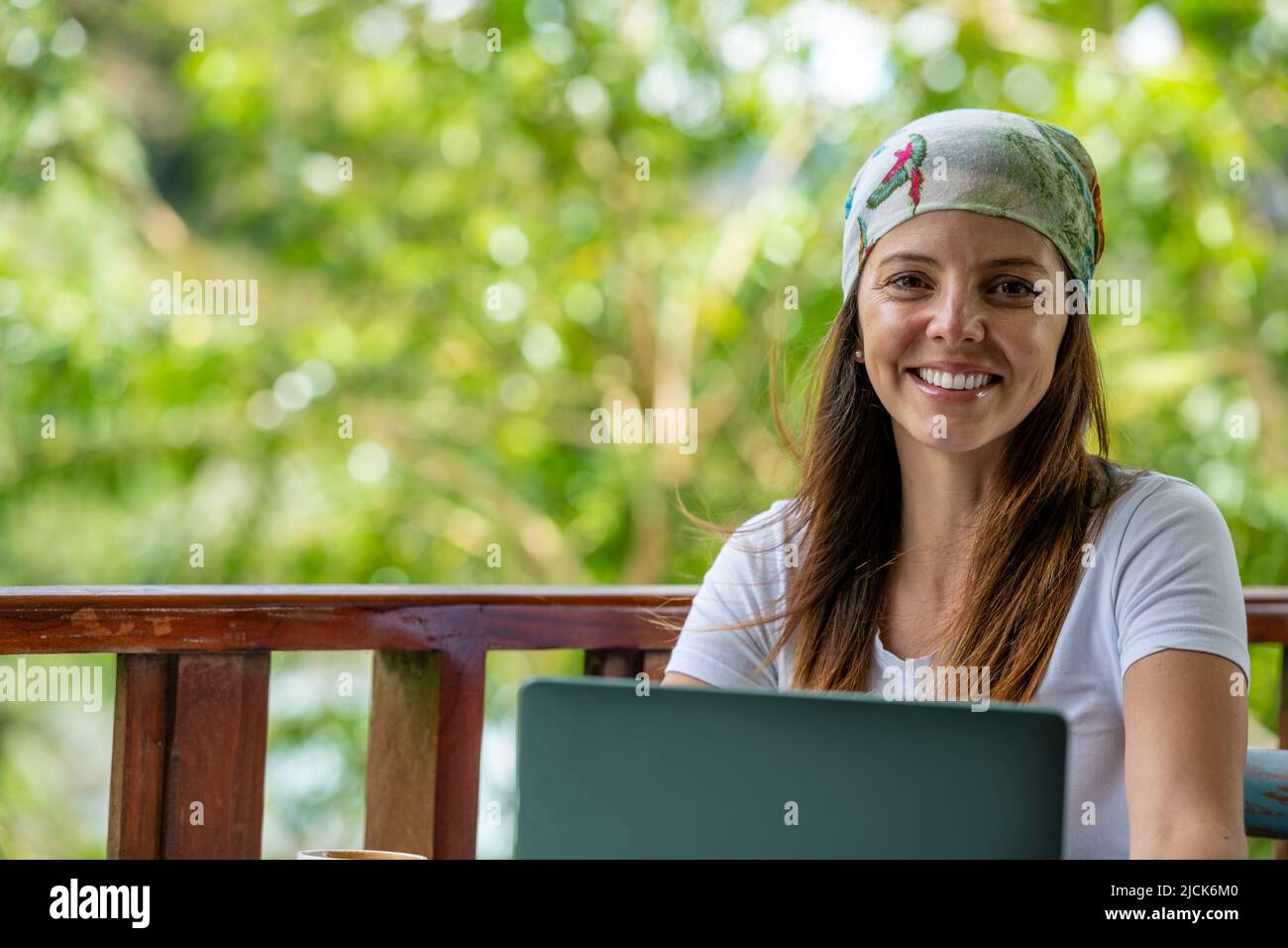 Young Latin American woman working on her laptop at a outdoor cafe while drinking a cup of coffee, Panama, Central America Stock Photo