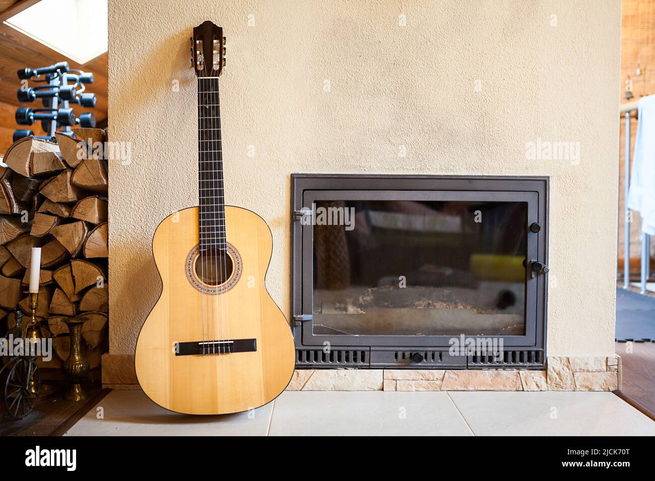Yellow acoustic guitar standing leaning wall of build-in mantelpiece in a domestic room Stock Photo
