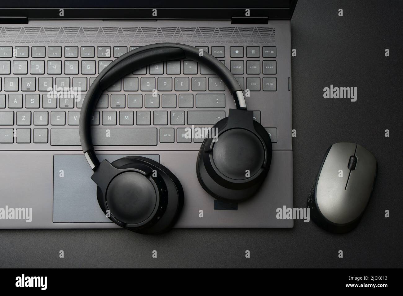 Headphones and laptop computer on black desktop. Listening to music, audio, sound concept. High quality photo Stock Photo