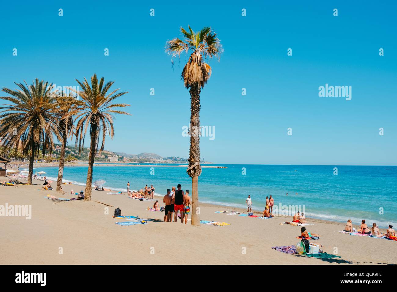 Malaga, Spain - May 26, 2022:  People enjoying the good weather in a sunny spring day in La Malagueta beach, in Malaga, Spain Stock Photo
