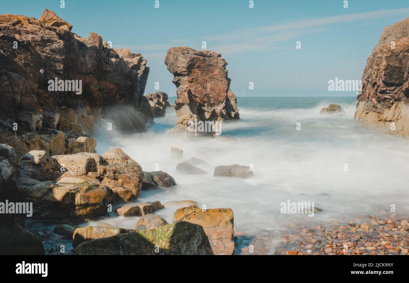 A small cove at Girdle Ness Lighthouse outside Aberdeen port in Scotland, using long exposure to slow down the water. Stock Photo