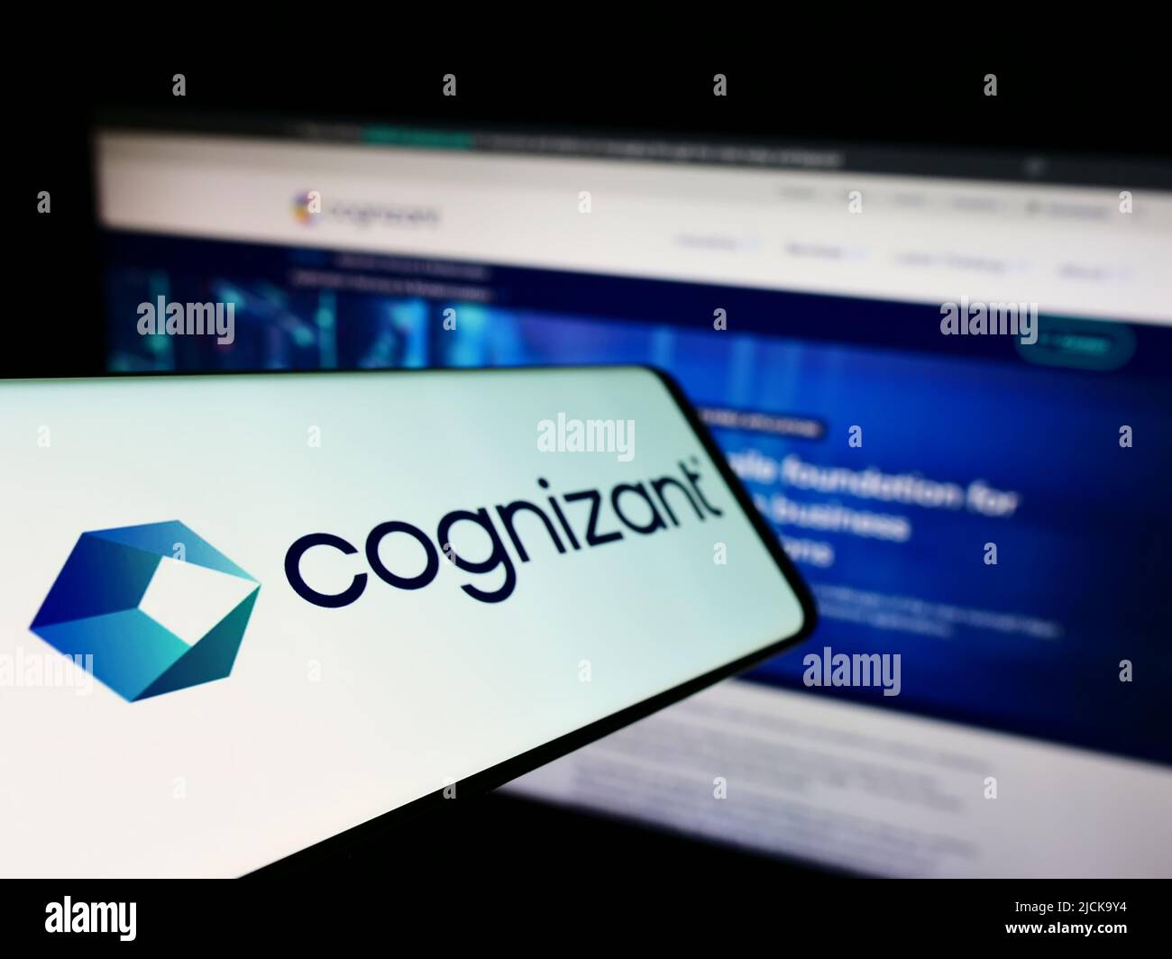 Cellphone with logo of Cognizant Technology Solutions Corporation on screen in front of busines website. Focus on left of phone display. Stock Photo