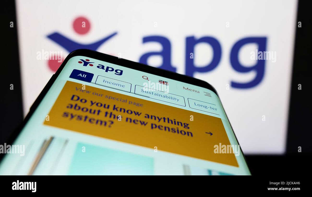 Mobile phone with website of pension fund Algemene Pensioen Groep (APG) on screen in front of business logo. Focus on top-left of phone display. Stock Photo