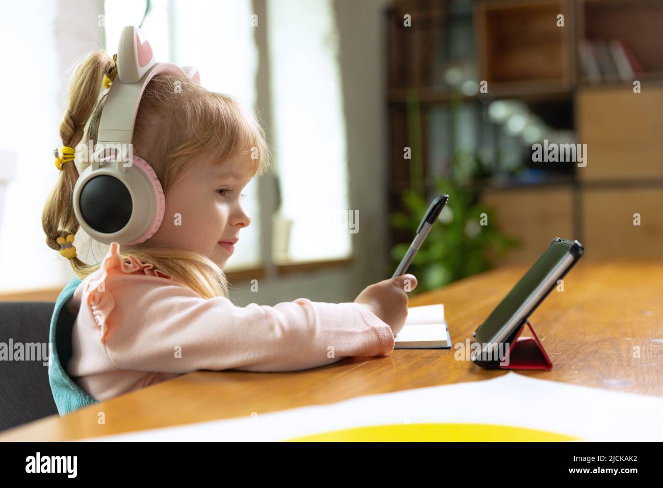 Live portrait of cute little girl, preschool age kid leaning at home ...