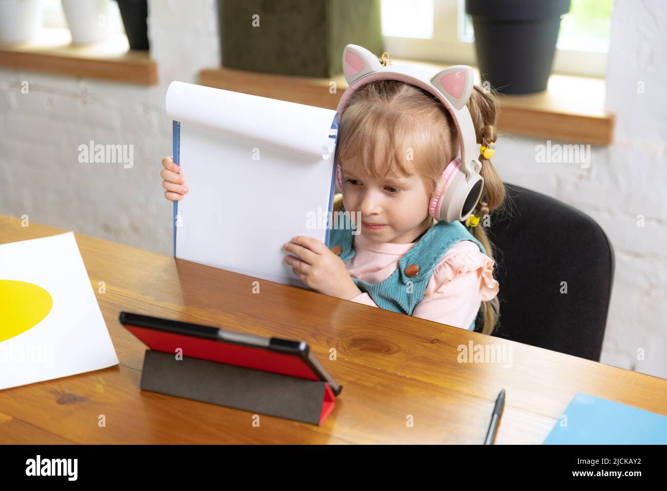 Live portrait of cute little girl, preschool age kid leaning at home ...