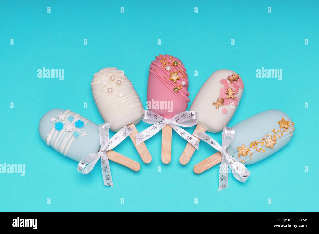 top view of decorated cake pops ice creams on turquoise background Stock Photo