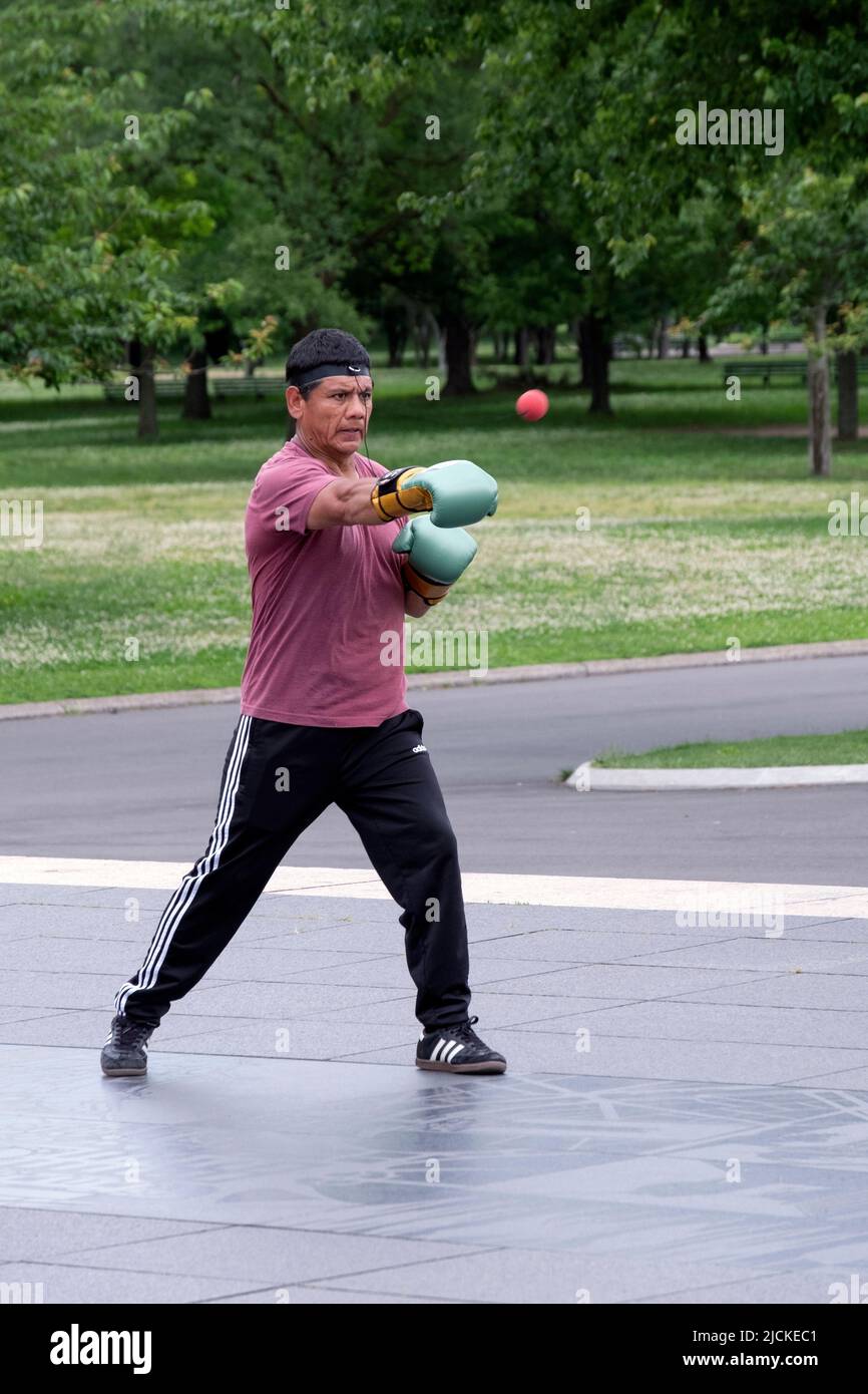 A boxer working out by punching a little red ball attached to his hat with an elastic string. In Flushing Meadows Corona Park in Queens, New York Ci. Stock Photo