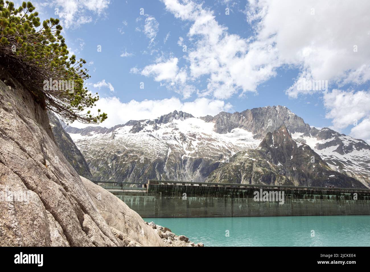 Alps mountains beautiful landscape with turquoise water lake and scenic mugs pine. High mountains nature and view on dam of Gelmer lake reservoir , su Stock Photo