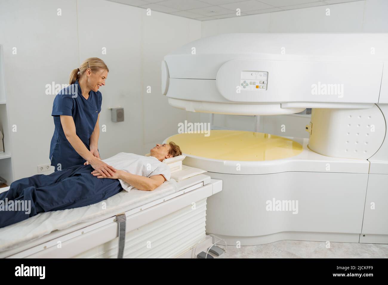 Radiologist controls MRI or CT or PET Scan with female patient