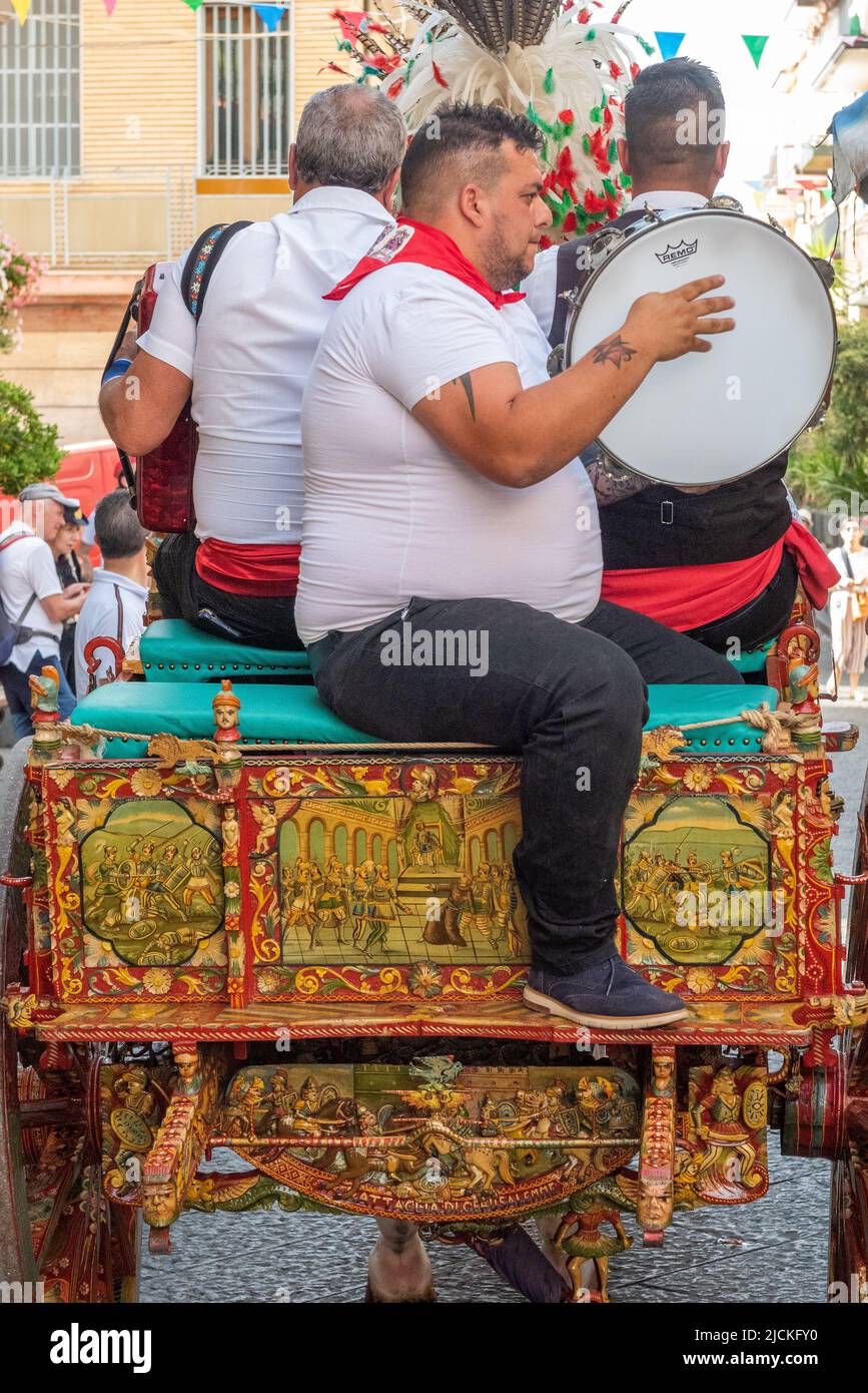 Traditional Sicilian folk musicians with their gaily decorated horse and cart - a 'carrettu sicilianu' - at a local festival in Maletto, Sicily Stock Photo