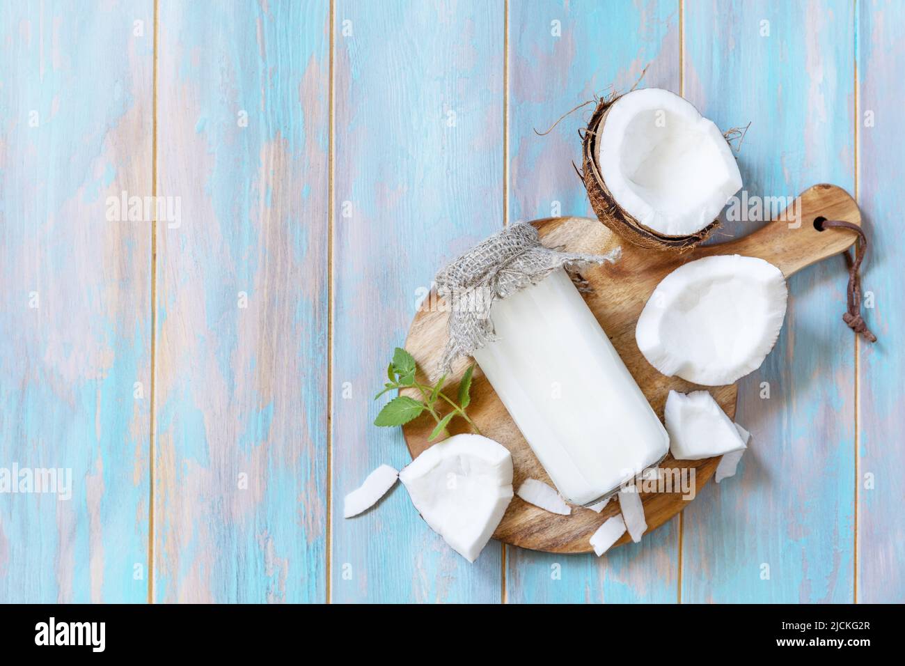 Vegan non dairy alternative milk, health content. Organic coconut milk in a bottle on a rustic table. View from above. Copy space. Stock Photo