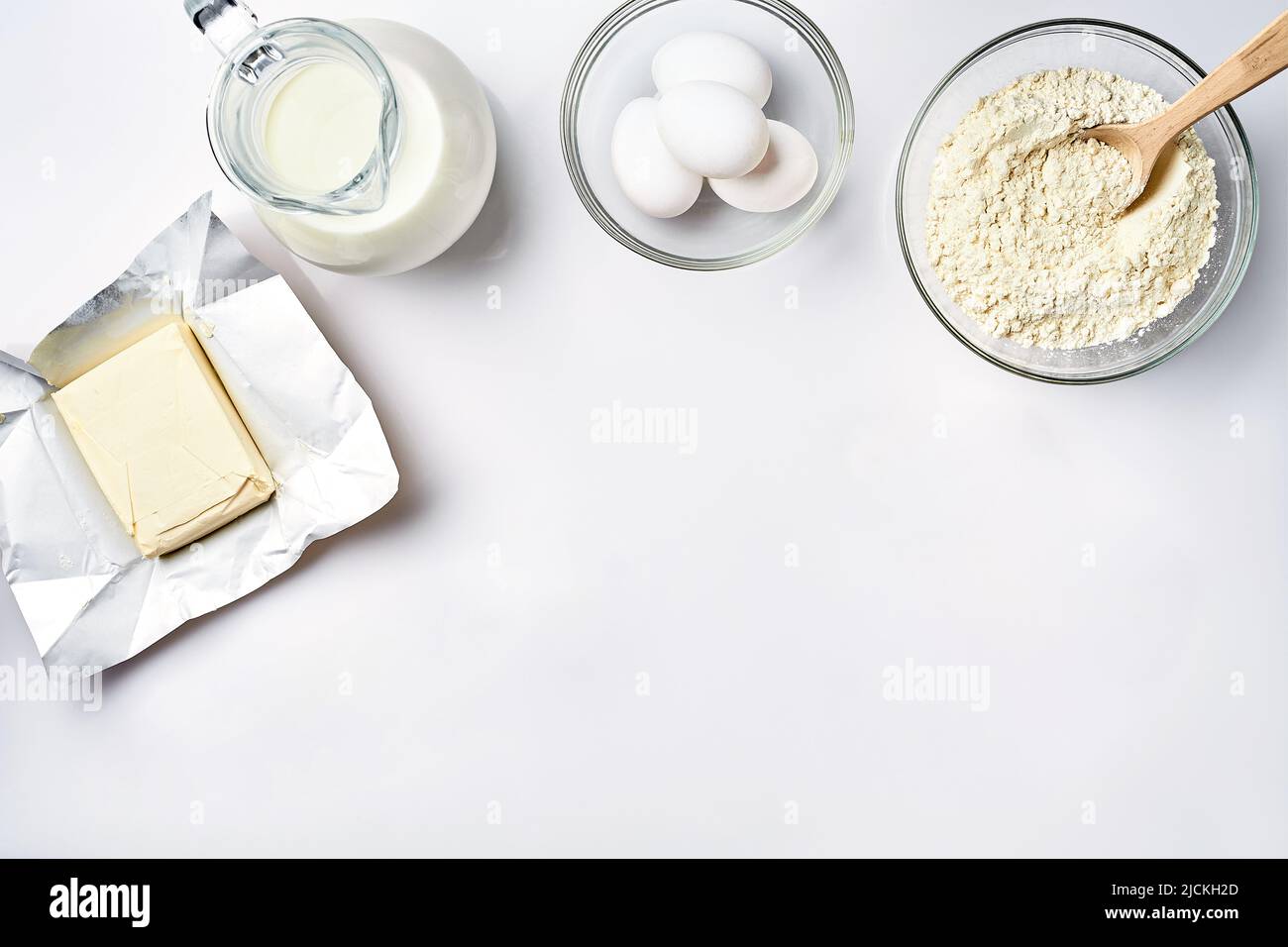 Wheat flour in the glass bowl, cream in a glass jar, butter, chicken