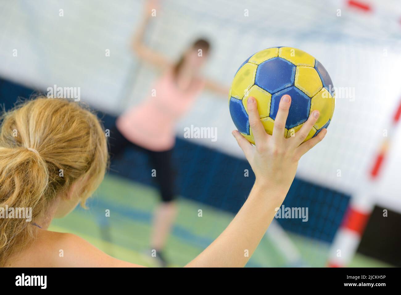 sportswoman holding a ball against handball field indoor Stock Photo