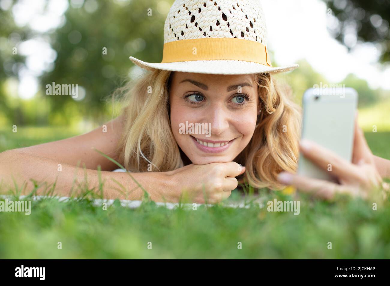 cute young girl laying on a grass at the park Stock Photo - Alamy