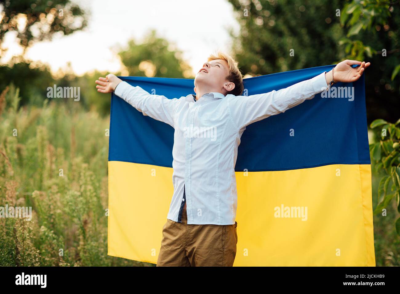 Ukraines Independence Flag Day. Constitution day. Ukrainian child boy in shirt with yellow and blue flag of Ukraine in field. flag symbols of Ukraine. Kyiv, Kiev day Stock Photo