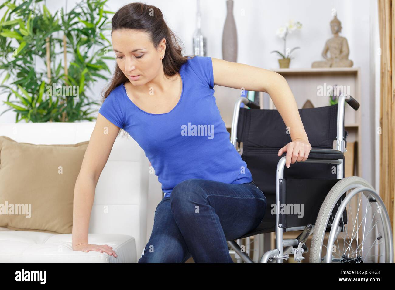 disabled woman in wheelchair moving to the sofa Stock Photo Alamy