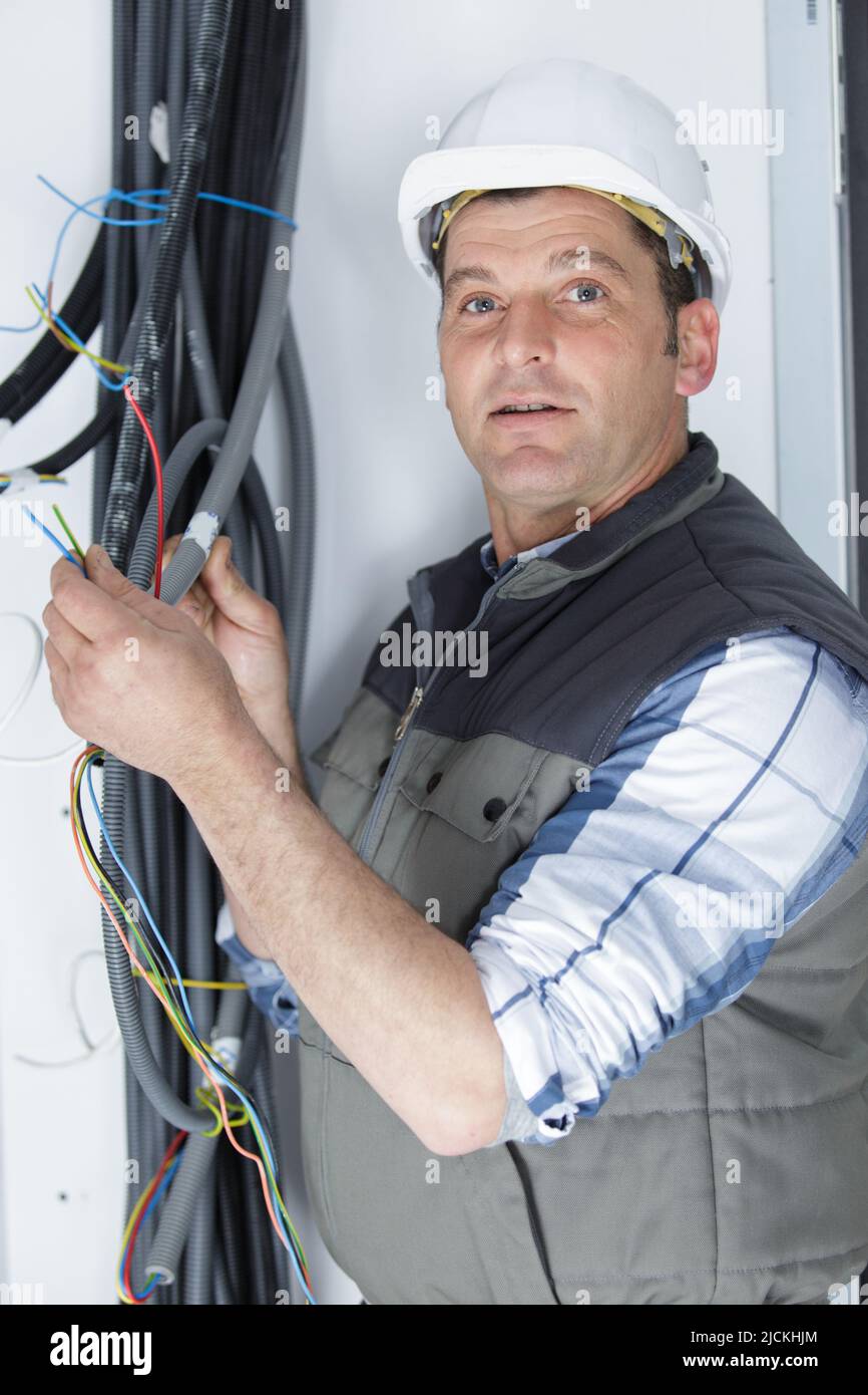electrician fitting wiring on construction site Stock Photo Alamy