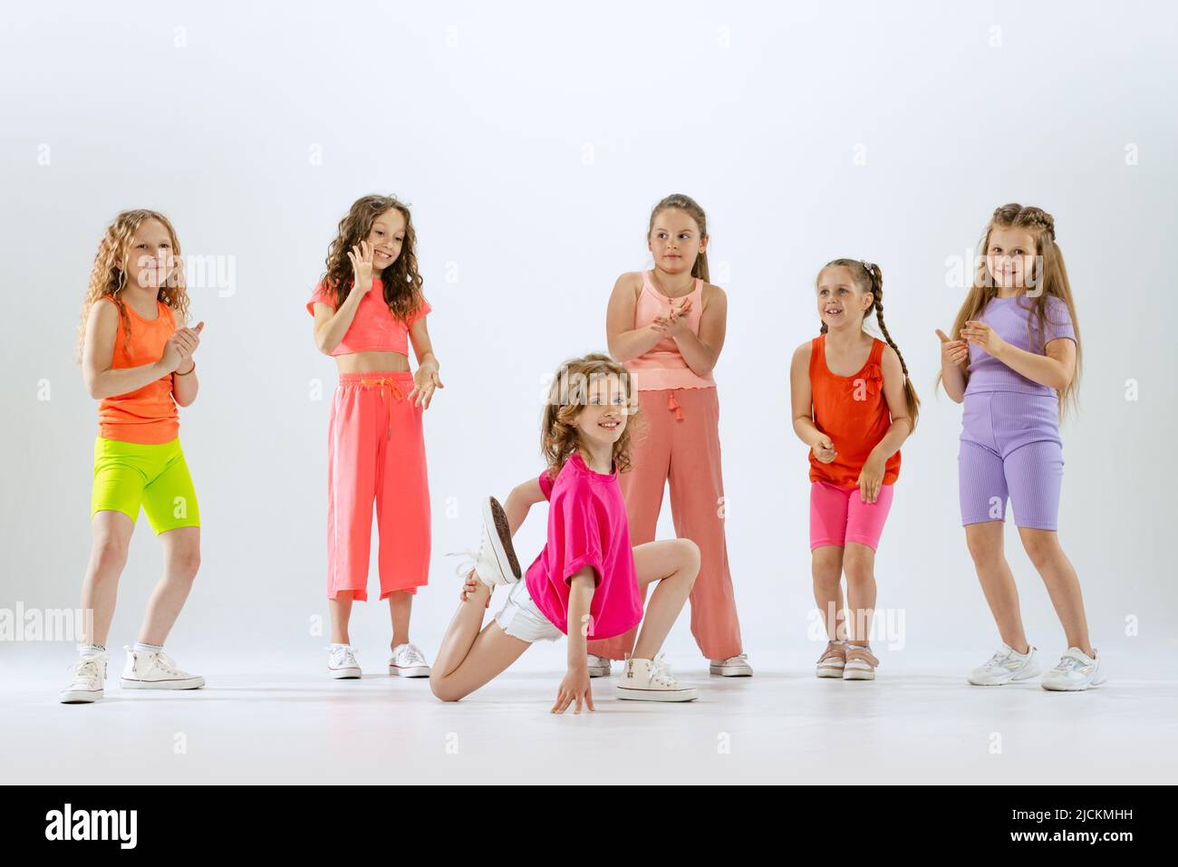 Dance group of happy, active little girls in bright colorful