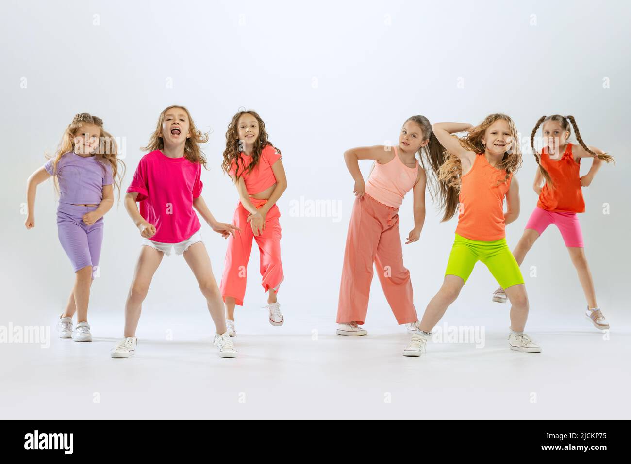 Dance group of happy, active little girls in bright colorful clothes ...