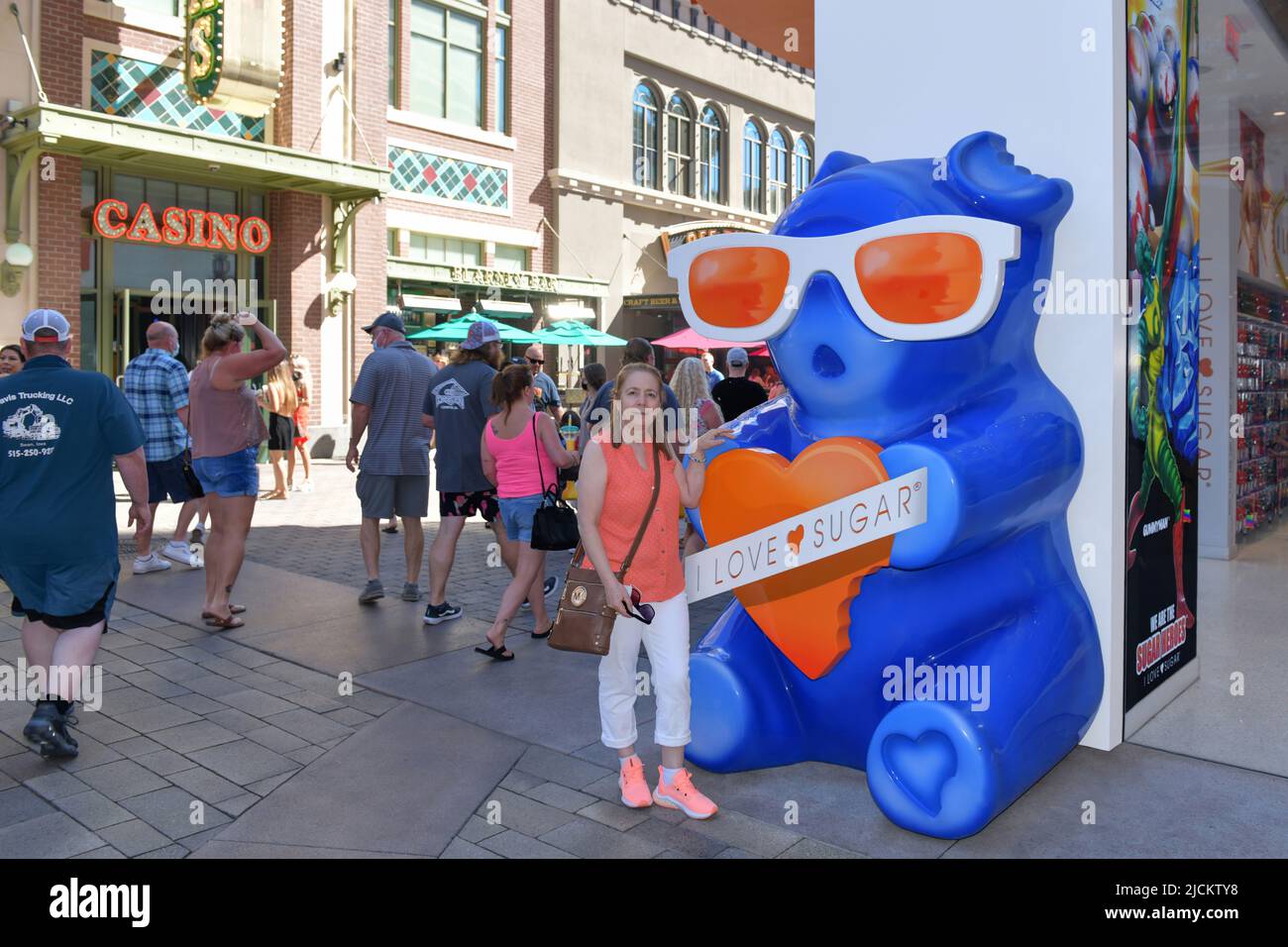 Nevada USA 05-09-21 A tourist poses next to a giant Gummy Bear symbol of the famous I LOVE SUGAR store located in The LINQ Promenade Las Vegas Stock Photo