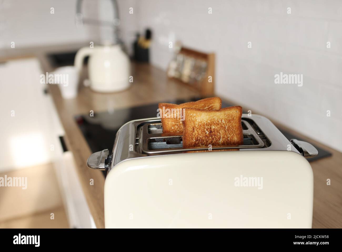 Toasted bread and toaster for breakfast. Modern white toaster and