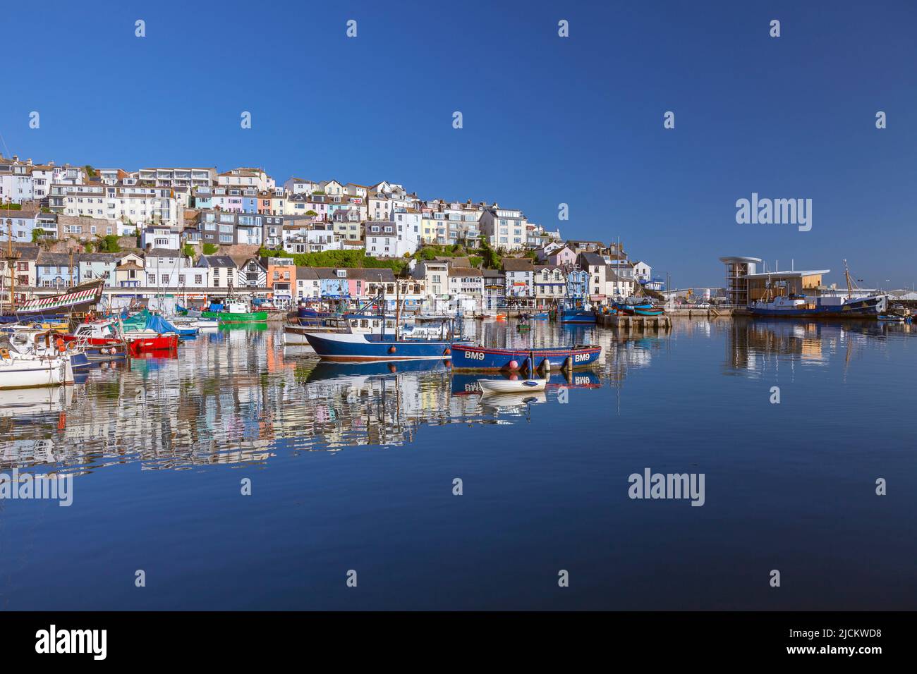 UK, England, Devon, Torbay, Brixham Harbour with The Quay and New Pier and moored Fishing Boats Stock Photo