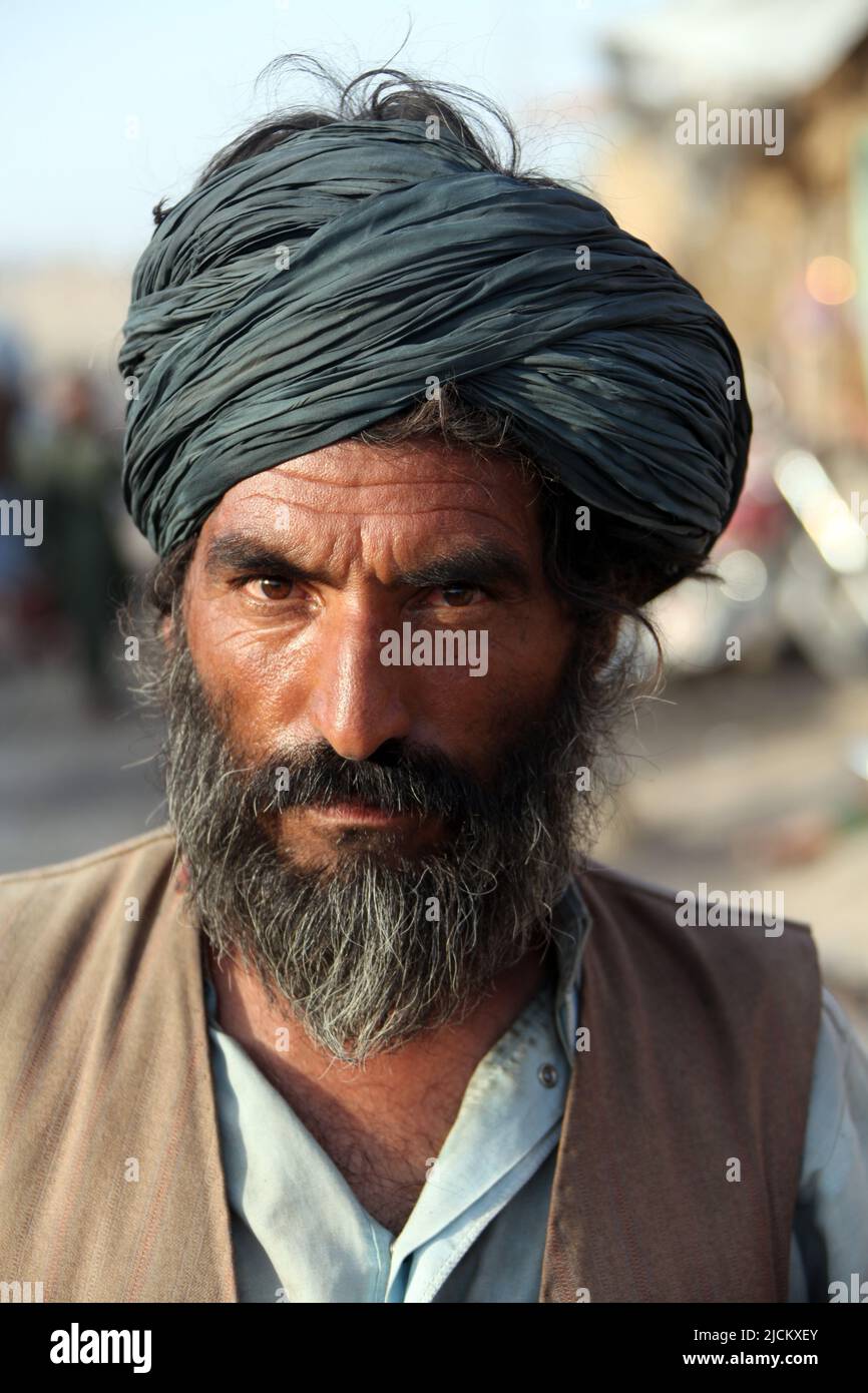Local Afghan shop owner stares deeply into the camera in Kajaki, Helmond Province, Afghanistan. Stock Photo