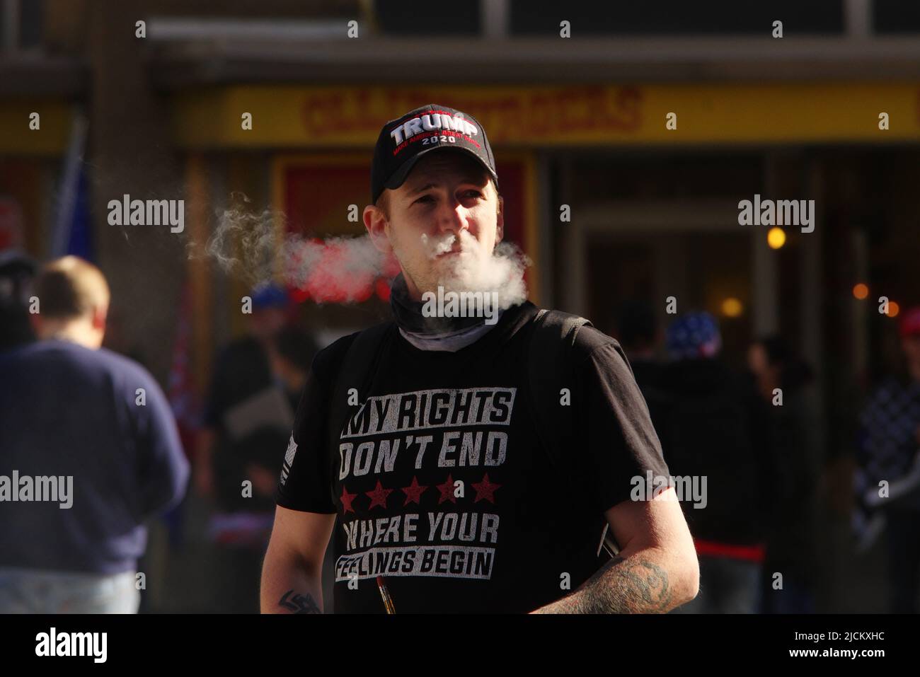 Washington - 14 November 2020: A pro-Trump protester vapes while walking to a rally to protest the 2020 presidential election. Stock Photo