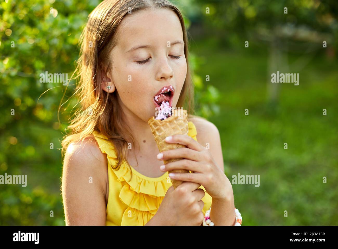 Happy girl with braces eating italian ice cream cone smiling while