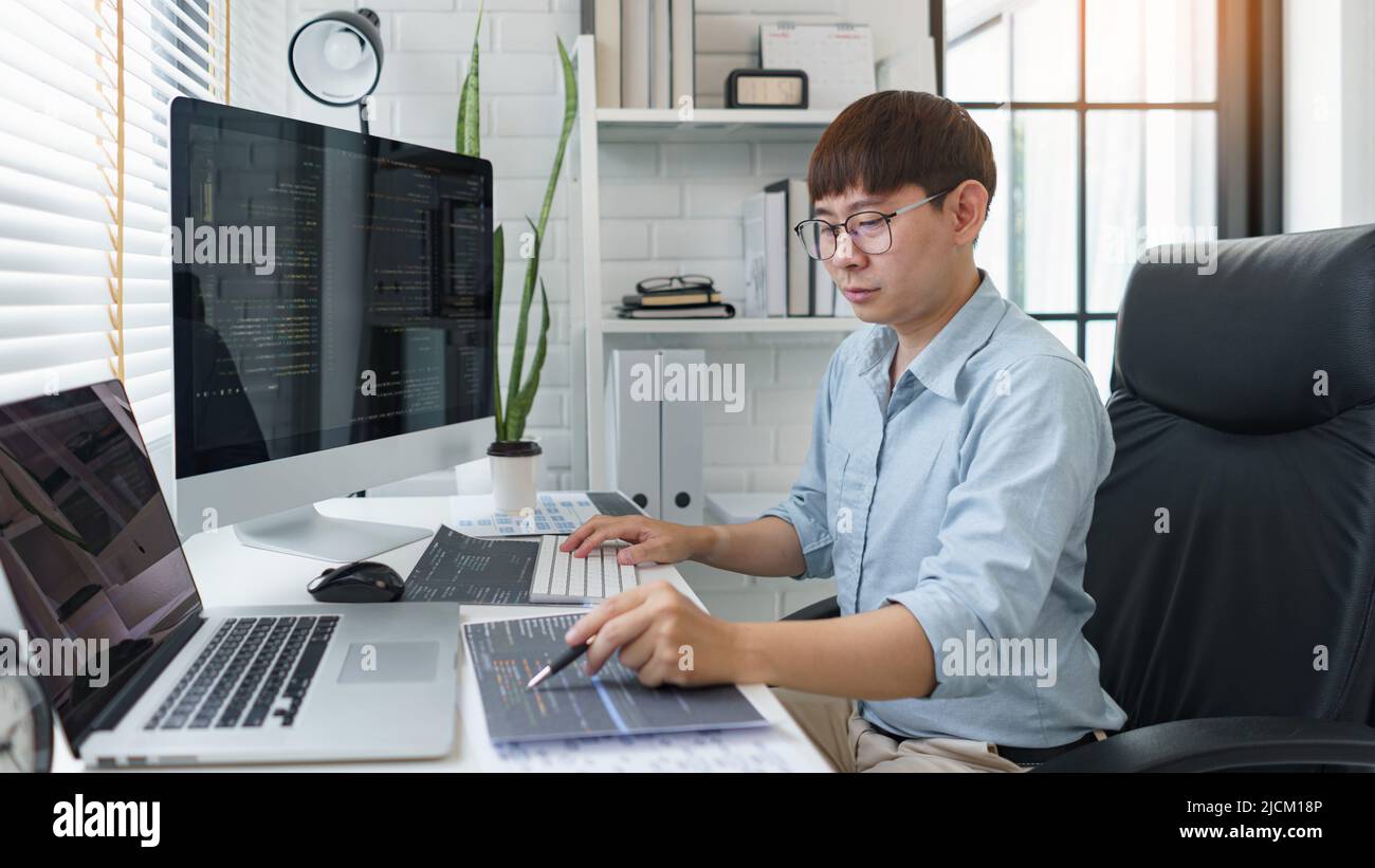 Software development concept, Male programmer pointing on data code to checking website programming. Stock Photo