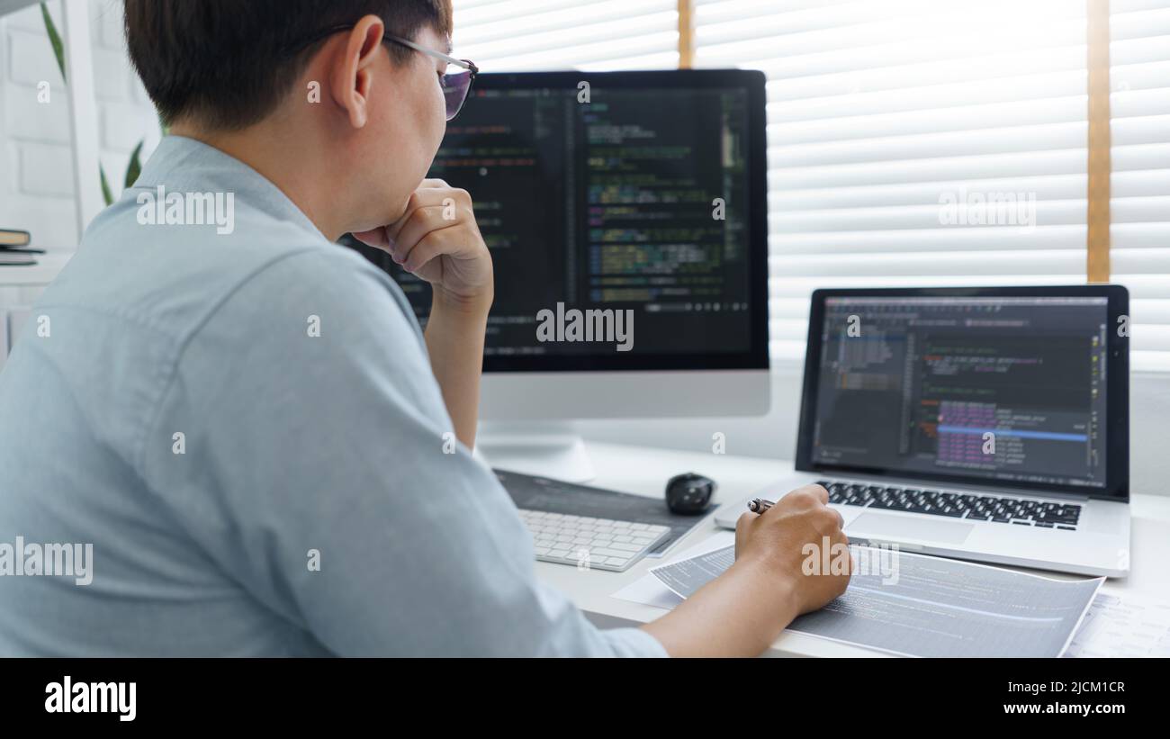 Software development concept, Male programmer read data code to thinking about developing website. Stock Photo