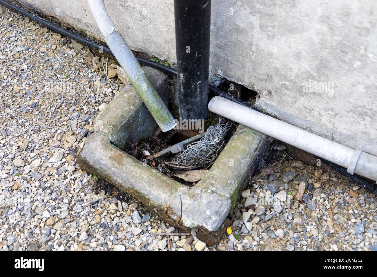 An  old drain blocked with mud, leaves & debris Stock Photo