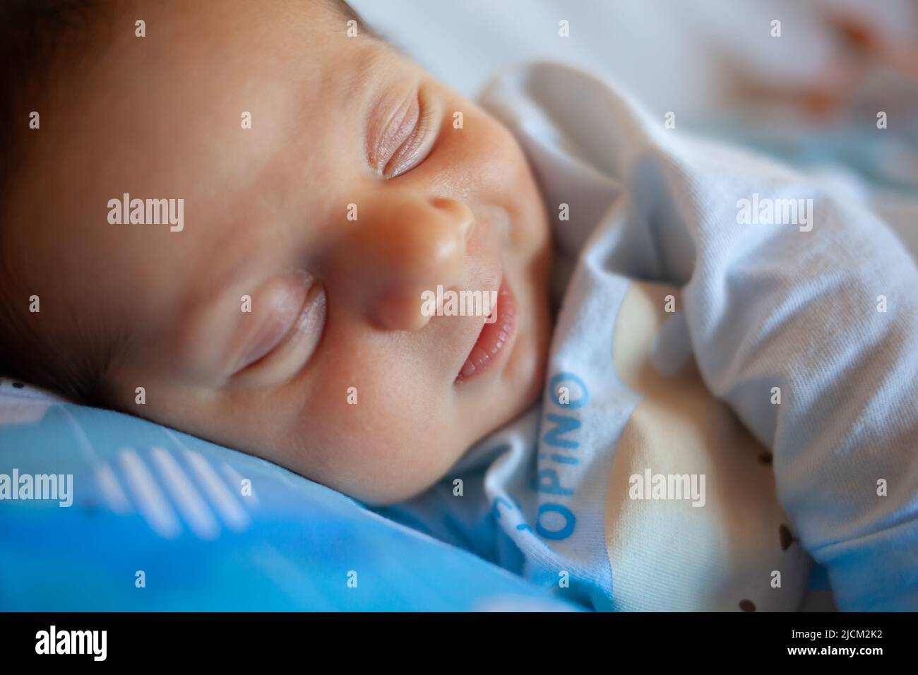 A few days old baby sleeps on a round pillow. The sleep phase is very important in childhood. Stock Photo