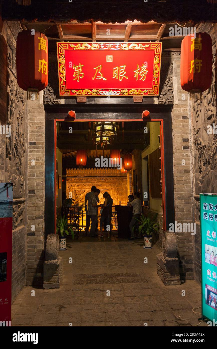 Entrance door gateway access from the street outside, at night evening, to enter into Gao 's Grand Courtyard / Gao Family Mansion; traditional ancient styled folk house at No144 of Bei Yuan Men. Former villa residence of Gao Yue Song, in Xi'an. PRC. China. (125) Stock Photo