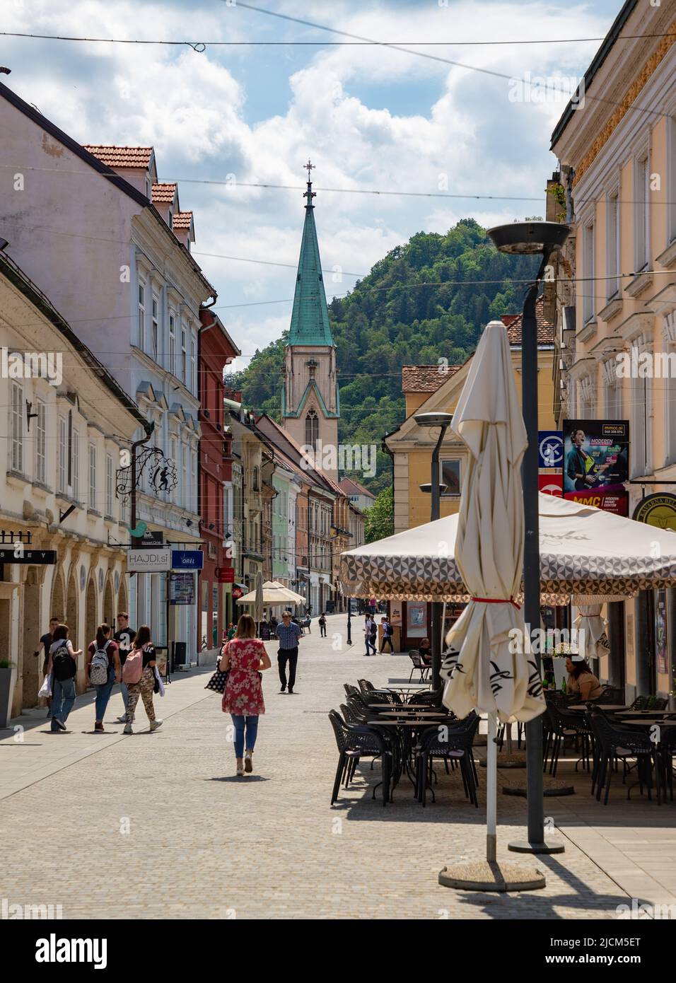 A picture of the busy Stanetova Street in Celje, with the tower of the Celje Cathedral in the distance. Stock Photo