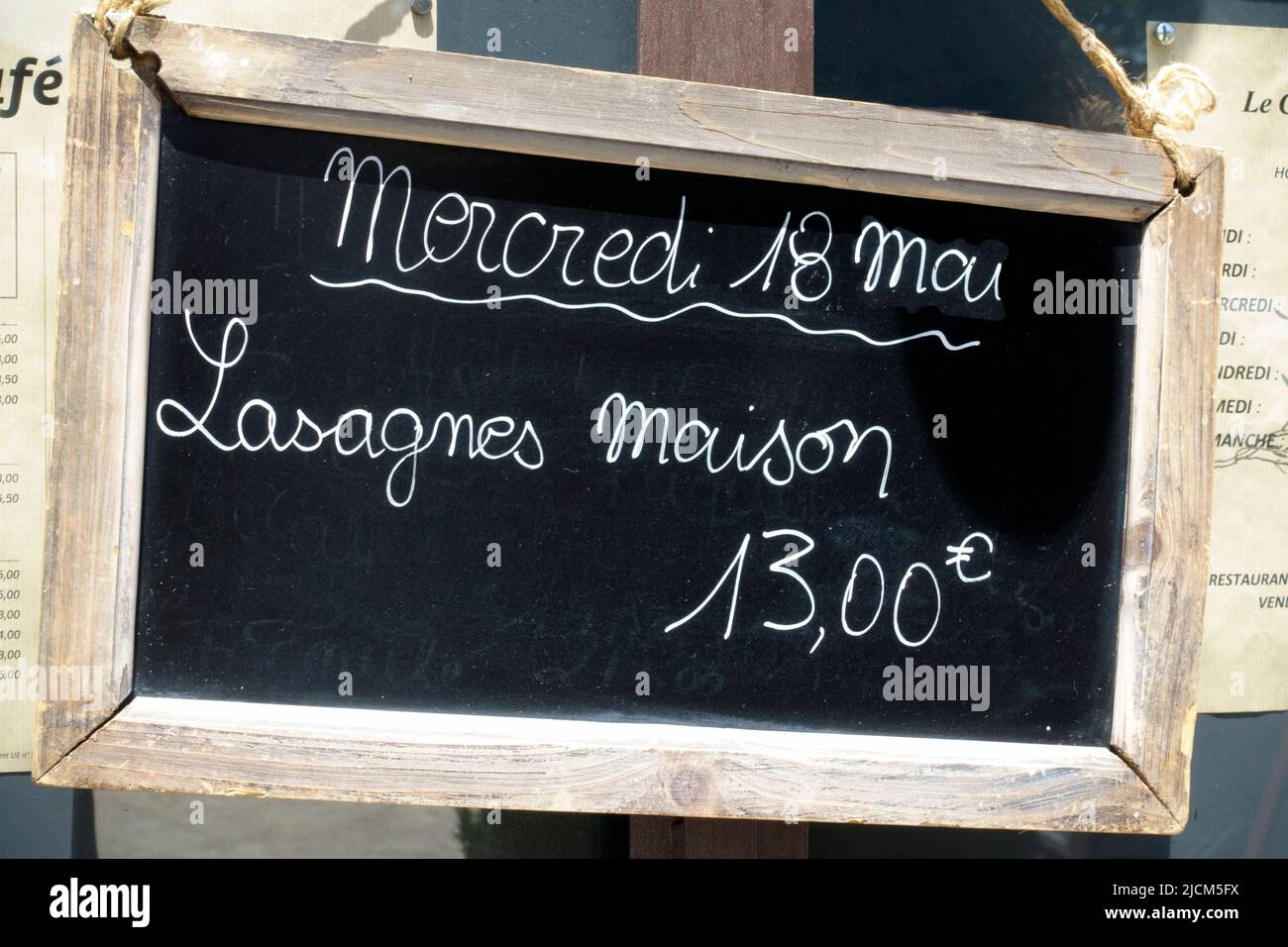 Menu sign n French at French restaurant telling the guest that the meal of the day at Wednesday 18 may is homemade lasagna and the price is 18 euros Stock Photo