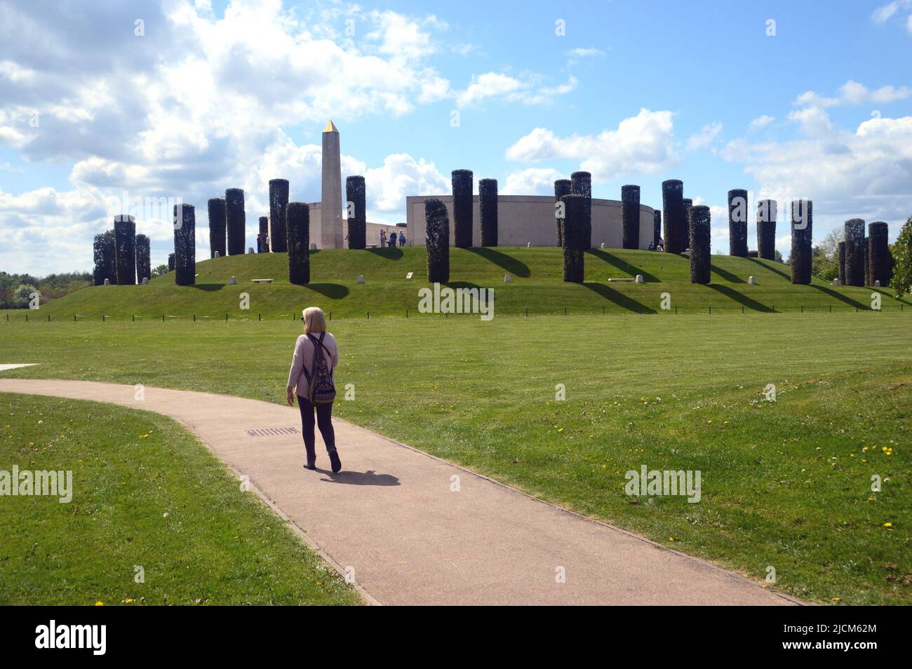 Lone Woman Walking on Path by The Armed Forces Memorial Mound at the National Memorial Arboretum, Airewas near Lichfield, Staffordshire, England, UK Stock Photo