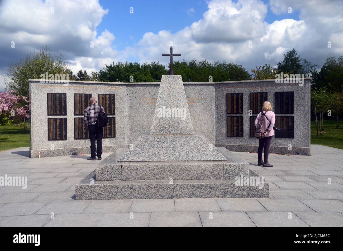 Two People at the Granite Replica of Camp Bastion Memorial Wall in Afghanistan at the National Memorial Arboretum, Staffordshire, England, UK. Stock Photo