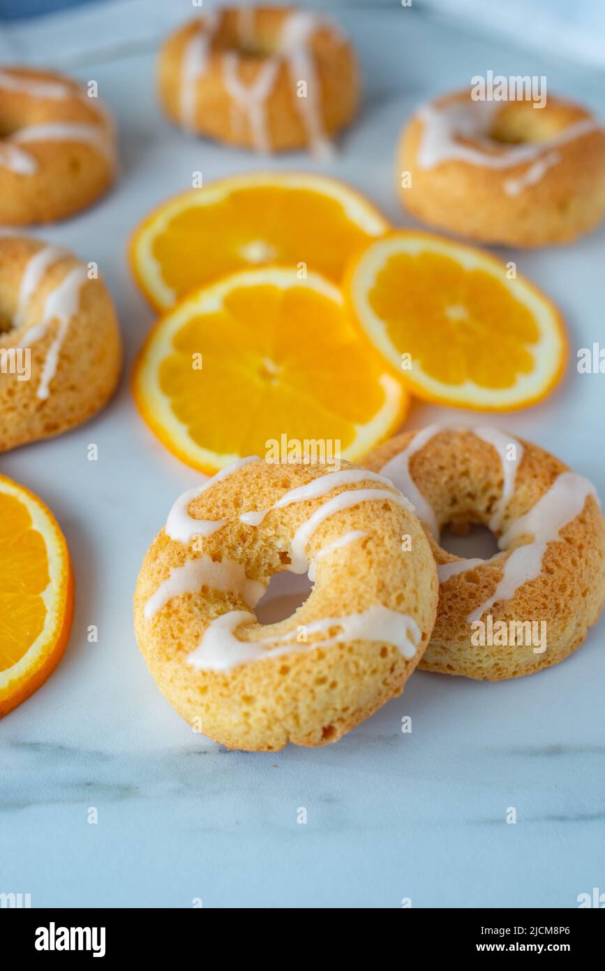 sweet home made orange donuts on a table Stock Photo
