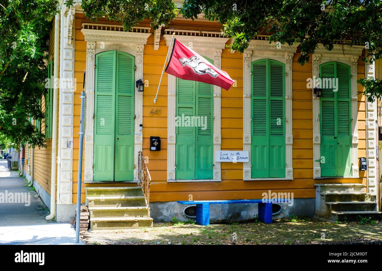 NEW ORLEANS, LA, USA - MAY 7, 2022: Tricolored historic shotgun house with an Arkansas Razorback flag in the Bywater Neighborhood Stock Photo