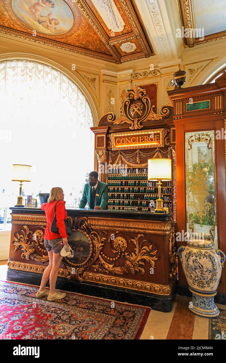 A hotel guest talking to the Congierge at the Grand Hotel des Iles Borromees, Stresa, Lake Maggiore, Italy Stock Photo
